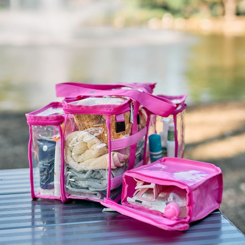 Toiletry items and towels packed into hot pink CamPaq toiletry bag sitting on bench