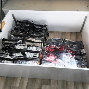 3 x large black trim clear camping bags packed with linen winter gear and shoes underneath caravan bed